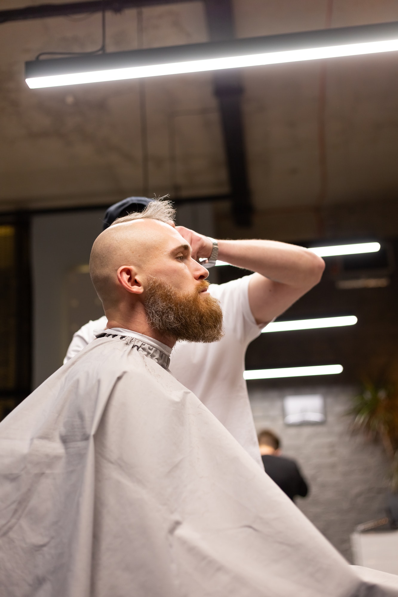 European brutal man with a beard cut in a barbershop